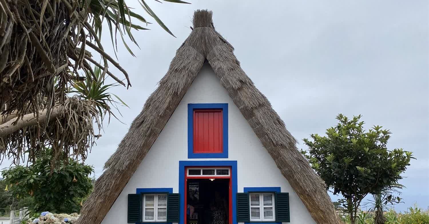 Maison traditionnelle triangulaire au toit de chaume Casa de Santana, avec des finitions rouges et bleues, à Santana, Madeira