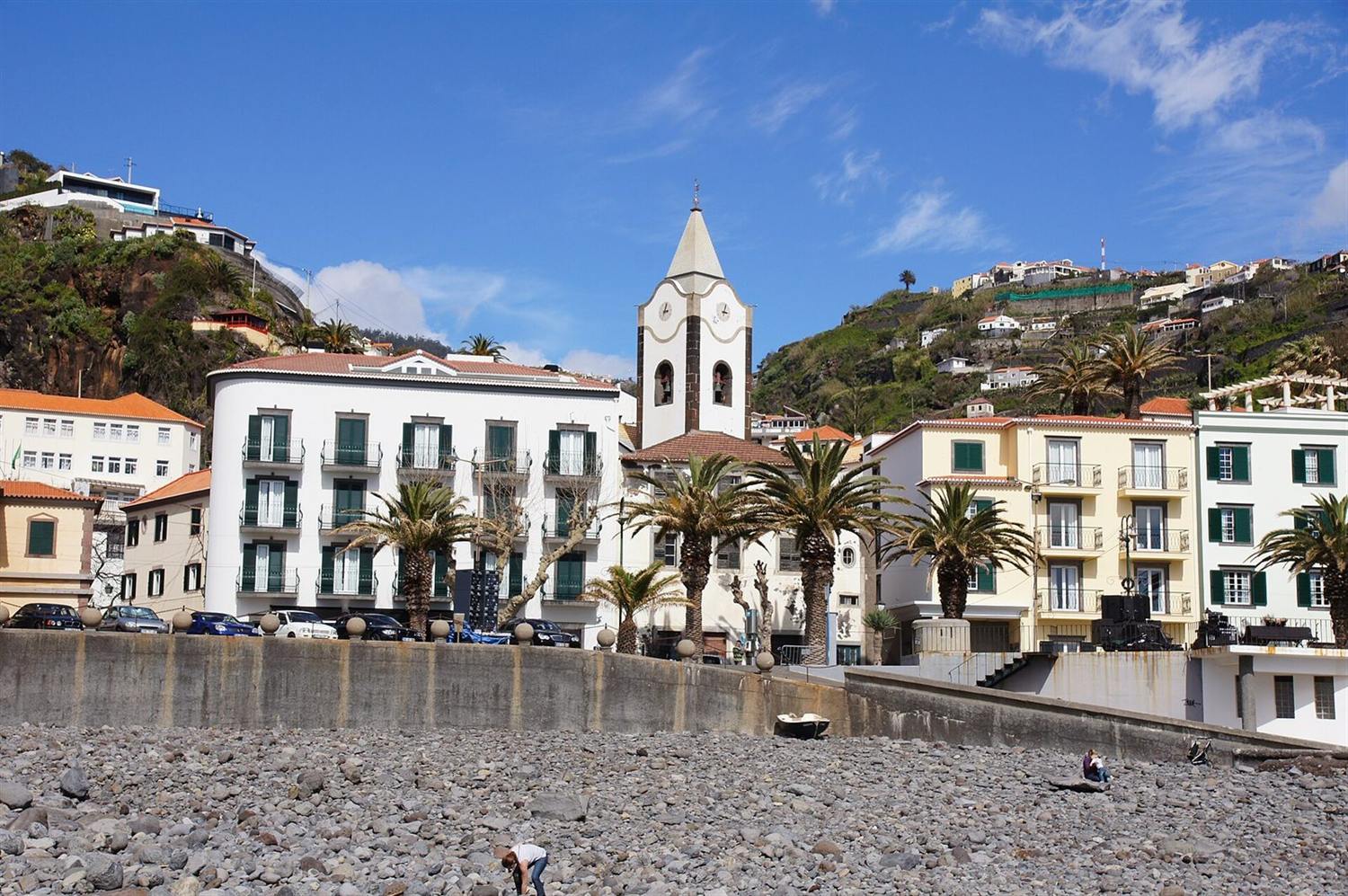 Ponta do Sol, Madeira, avec sa tour de l'horloge et son coteau en terrasses vus depuis la plage de galets